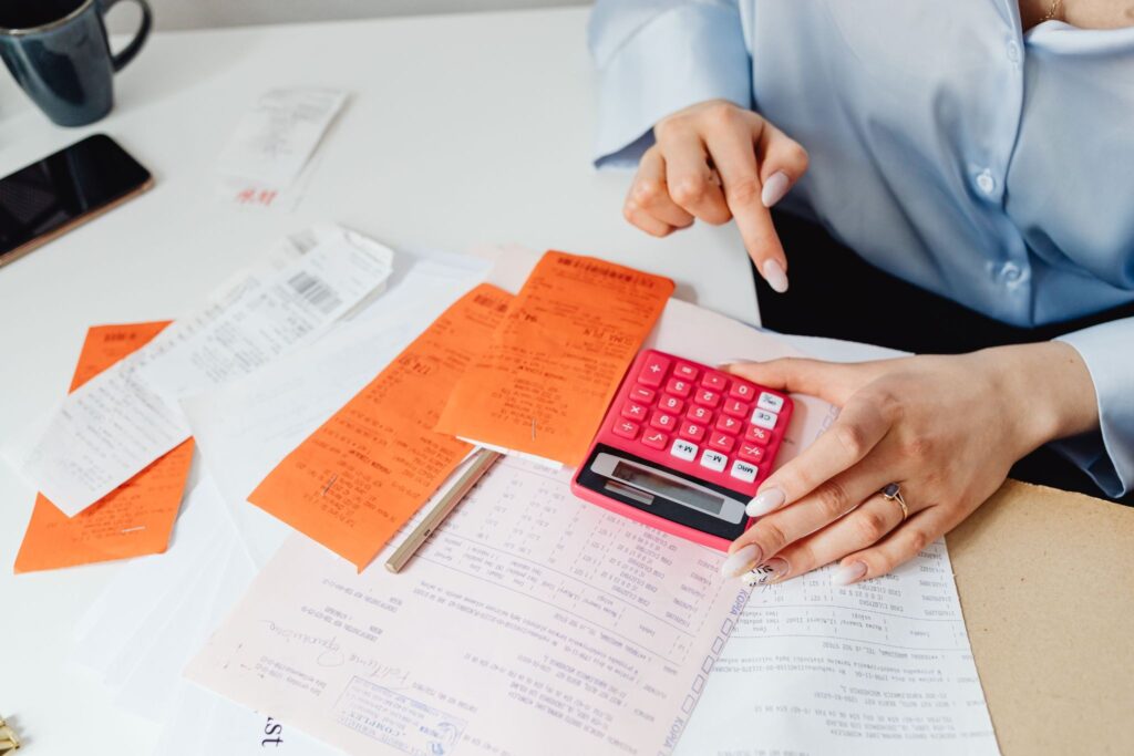 Calculating employee salary and payroll deductions with receipts and calculator